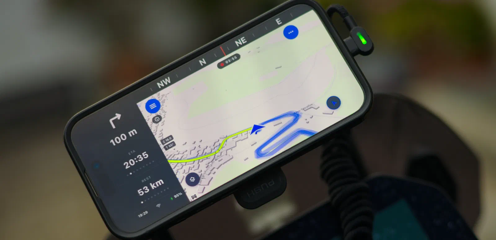 A phone mounted sideways on the handlebars shows the map, the route and the next turn in 100 meters.