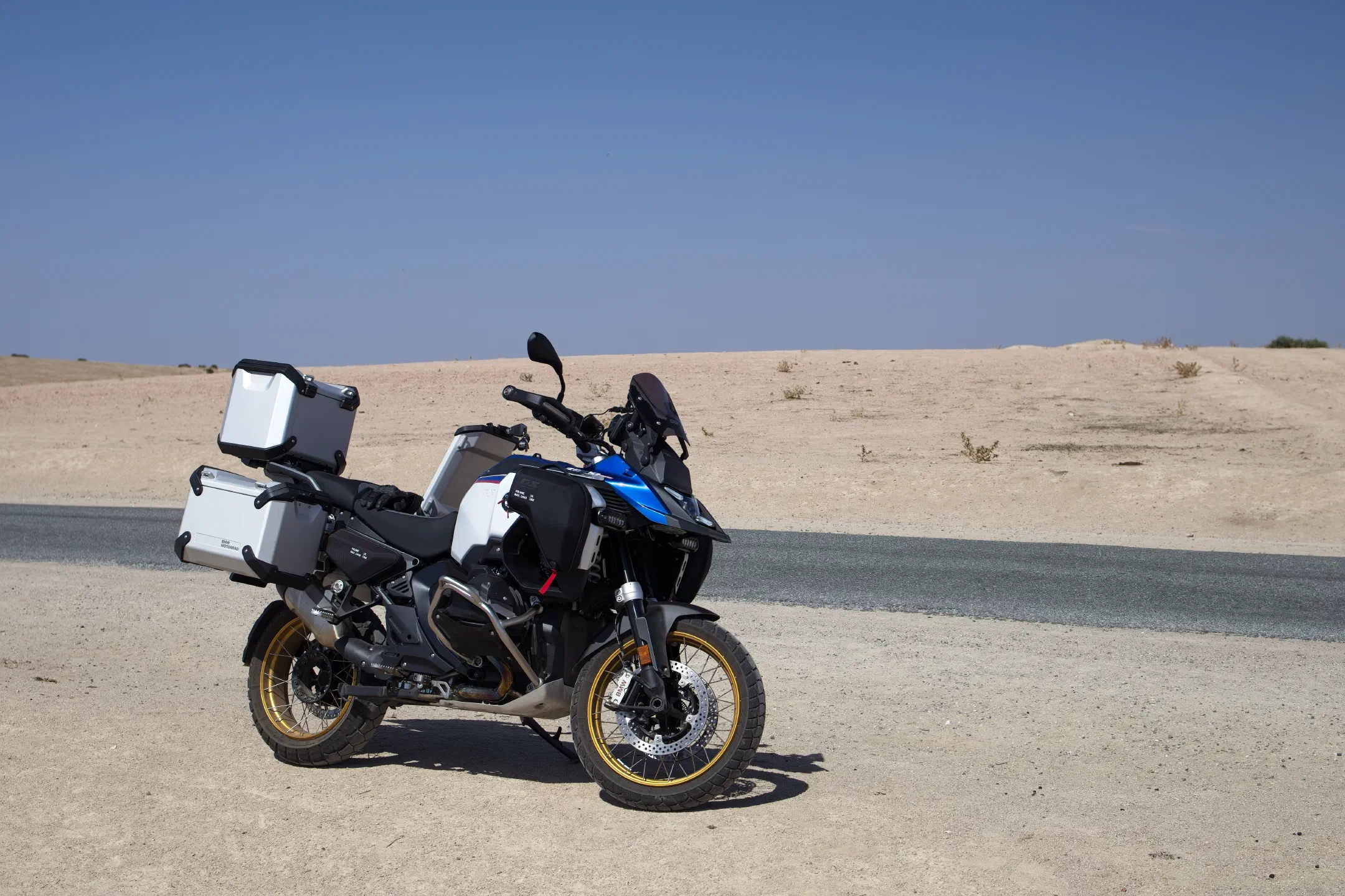 Morocco, edge of the semi-desert: a GS with aluminum cases, and a ribbon of asphalt next to it.
